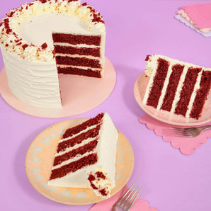 Vegan Red Velvet Cake by Crumbs & Doilies with four moist layers and creamy vegan buttercream icing on purple background